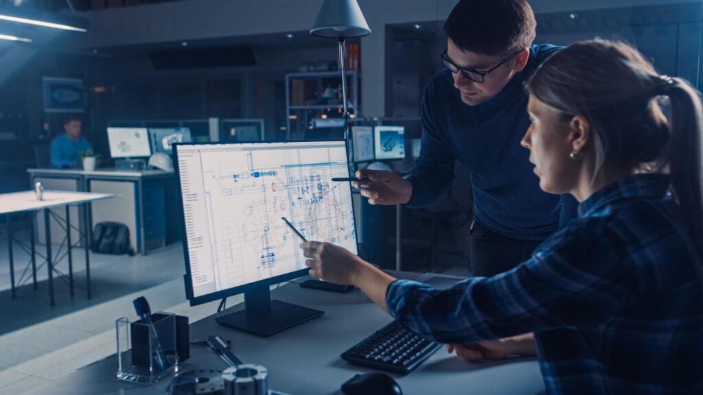 Ihr männlicher Projektmanager erklärt die Aufgabenspezifikationen des Desktop-Computers, der Bildschirm mit CAD-Software mit technischen Entwürfen. Büro für Industriedesign (1515878147) - shutterstock.com